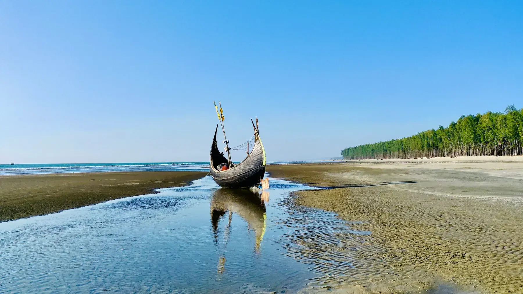 A wooden fishing boat resting on Cox's Bazar Beach
