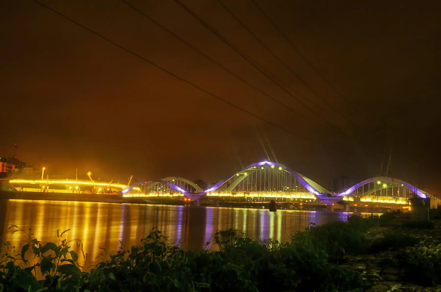 Hatirjheel's illuminated bridge reflected at night