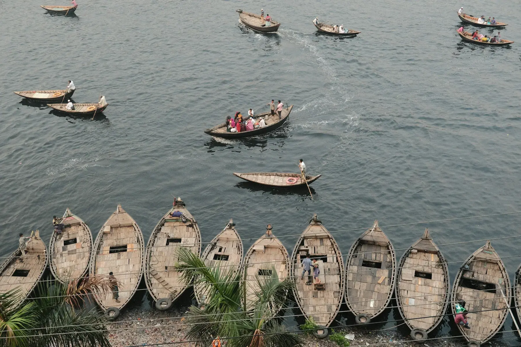 Rows of wooden boats at a busy Bangladesh river landing