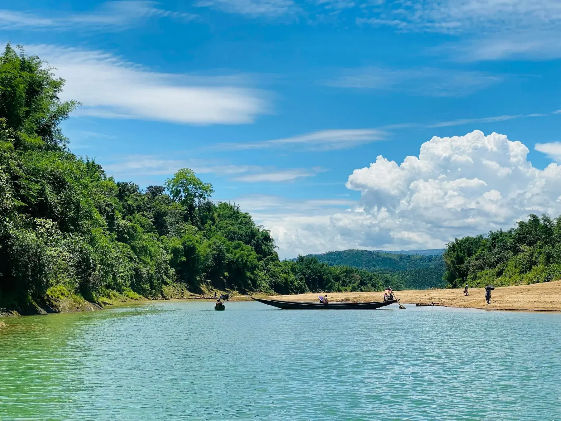 A boat crossing the green Surma River near Sylhet