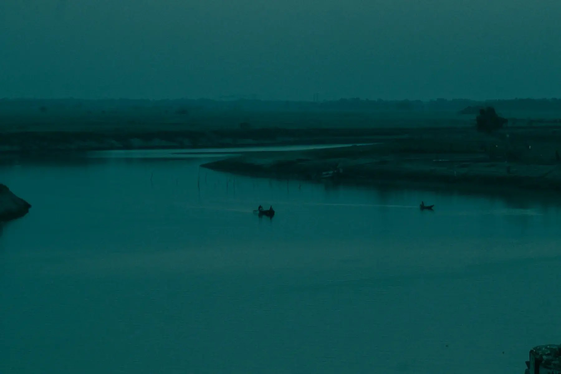Small boats on the Surma River at dusk