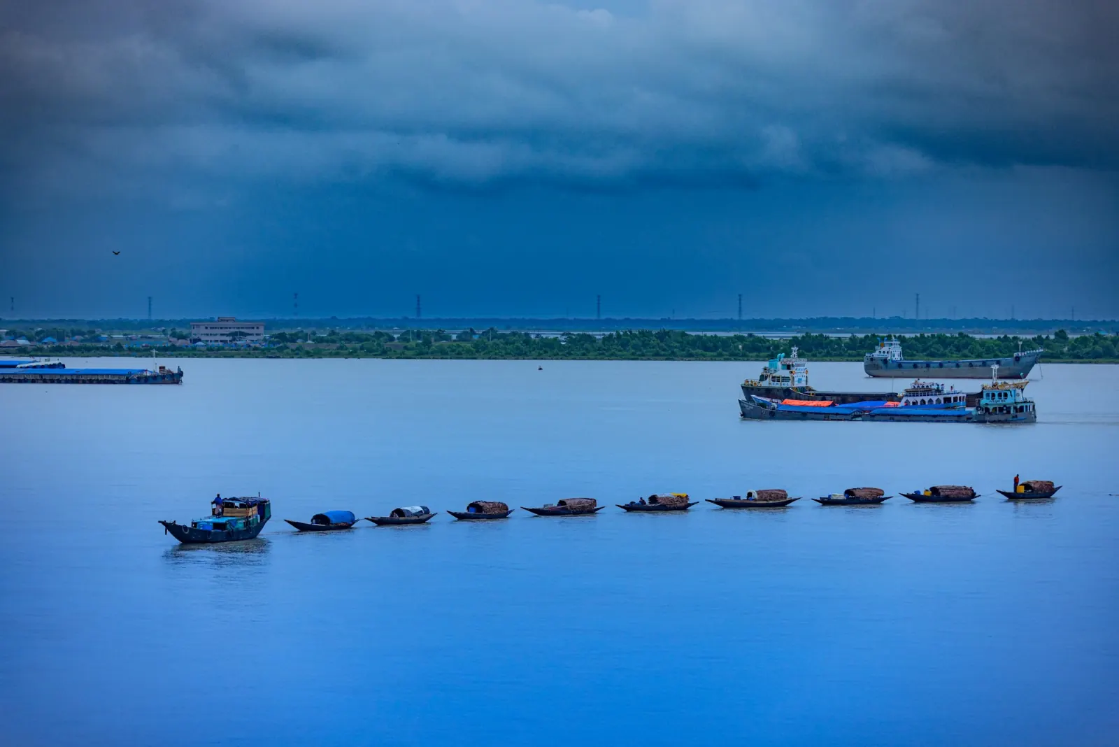 Fishing boats returning across a wide river near Khulna during the Barishal River & Floating Market Tour